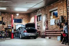 A garage interior with a man working on his car.